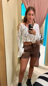 Blusa de encaje blanca con mangas largas acampanadas.