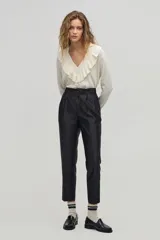 Sweater color crema de tejido de punto con lurex, escote en V con volados y mangas largas.