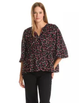 Blusa de gasa con estampado de corazones rojos y blancos sobre fondo negro. Presenta cuello redondo con escote en V, mangas largas con puños fruncidos y un corte holgado con detalle de frunces en la cintura.