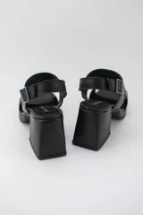 Sandalias negras de cuero con plataforma y taco ancho.