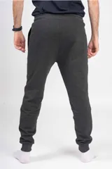 Pantalón de jogging unisex de felpa, color verde oscuro, con cintura elástica con cordón de ajuste y puños elásticos en los tobillos.