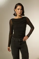 Body de manga larga con diseño al cuerpo, confeccionado en tela con textura suave y detalles de frunces en el frente. Presenta un elegante cuello bote y cierre inferior con broches.