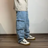 Jean cargo de corte recto y tiro medio, confeccionado en denim de algodón en tono azul claro. Presenta bolsillos laterales tipo cargo con solapa y costuras reforzadas.