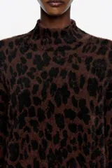 Sweater largo de corte recto, cuello alto y manga larga, confeccionado en tejido de pelo con estampado de leopardo en tonos marrón y negro.