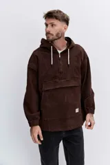 Campera tipo canguro color marrón, con capucha, cierre frontal parcial y bolsillo tipo sobre en el frente. Presenta puños elásticos y cordones ajustables en la capucha.