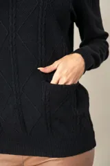 Sweater gris de punto con cuello redondo y mangas largas. Presenta diseño trenzado en el frente y dos bolsillos delanteros.