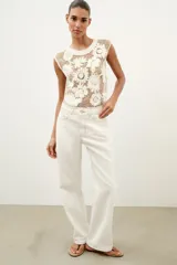 Top de crochet color crudo, sin mangas, con cuello redondo y detalle de aplicaciones de flores en relieve.