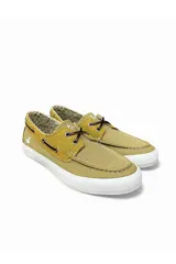 Zapatos náuticos de lona color mostaza, con suela blanca, cordones marrones cruzados y detalles de costuras a contratono.