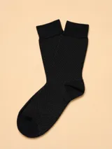 Medias de algodón en color negro con textura de micro-puntos, diseñadas con puño elástico reforzado.
