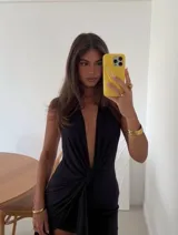 Vestido corto negro con escote halter profundo y detalle de nudo frontal con caída de tela. Confeccionado en doble capa de microtul.