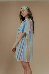 Vestido corto tejido a rayas verticales de colores pastel, con cuello camisero, cierre frontal con botones y bordado de flores de crochet.