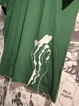 Remera verde con estampado de una mano blanca.