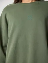 Sudadera verde militar de algodón orgánico, corte oversize, con cuello redondo y puños acanalados. Estampado en el frente y la espalda con diseño de fogata y texto 'Blue Banana'.