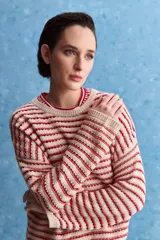 Sweater de tejido amplio en color azul marino con diseño de rayas horizontales y detalles calados. Cuenta con cuello redondo, mangas largas con hombros caídos y terminaciones acanaladas.