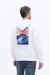 Canguro blanco con capucha y bolsillo frontal, que presenta un estampado artístico de una montaña con atardecer en la espalda y la frase 'Find your focus'.