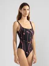 Malla entera negra con estampado de cadenas y flores rosadas. Incluye cinturón fino con hebilla dorada.