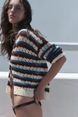 Chaqueta de punto calado con cuello redondo, manga larga y diseño a rayas horizontales en tonos blanco, azul y bordó. Cuenta con cierre frontal de botones y terminaciones en rib.