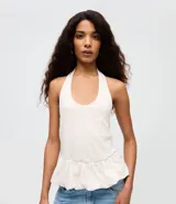 Blusa color blanco de cuello halter con espalda descubierta y diseño peplum en el ruedo.