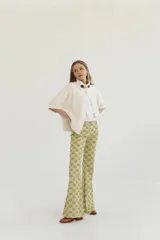 Pantalón acampanado con estampado abstracto en tonos verde y dorado.