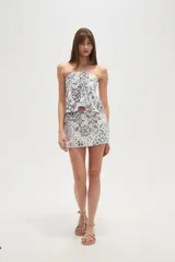 Top strapless de viscosa con estampado de azulejos en tonos azul y blanco. Presenta un diseño con cuello halter, detalle de fruncido central y un lazo decorativo en el frente.