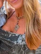 Collar plateado con cadena gruesa y dije en forma de sol.