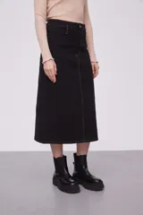 Falda midi de jean color negro, de tiro alto y corte recto. Presenta costuras a la vista en color ocre y cierre frontal con botón y cremallera.