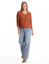 Buzo de tejido fino con escote en V, mangas tres cuartos estilo dolman y corte holgado.