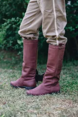 Bota alta de cuero marrón, con suela de goma y detalle de tira con hebilla en la parte superior de la caña.