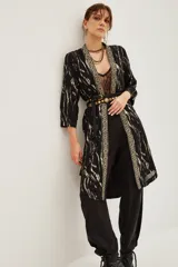 Kimono largo de jacquard con diseño de cebra y destellos de lurex. Presenta bordes con detalle de guarda tejida, mangas tres cuartos y forro interior.
