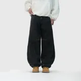 Pantalón de jean estilo baggy, color negro con efecto lavado. Presenta un corte extremadamente holgado, bolsillos traseros con bordes deshilachados y un diseño de llamas bordado en uno de los bolsillos traseros.