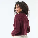 Sweater de punto con diseño de trenzas verticales, cuello alto y puños acanalados.