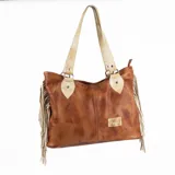 Cartera tipo shopper de cuero en color marrón con efecto gastado, asas y detalles en cuero natural, y flecos colgantes en los laterales. Cuenta con cierre superior y placa metálica con la marca grabada.