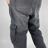 Pantalón cargo negro de corte recto, con bolsillos laterales con fuelle y cierre de solapa.