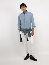 Camisa de micropana celeste para hombre, de corte regular fit y manga larga. Cuenta con cuello abotonado, cierre frontal con botones y detalle de vivo liso en el interior de los puños.