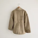 Chaqueta de silueta relajada, confeccionada en paño de lana color verde militar con detalles en pana de algodón marrón en el cuello y los bolsillos. Cuenta con cuello alto, bolsillos frontales amplios y cordón regulable en la cintura.