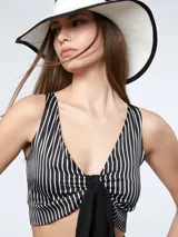 Top corto de satén a rayas verticales blancas y negras, con escote en V y nudo en la parte delantera.