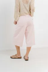 Bermuda de tiro medio con corte recto y largo por la rodilla, estilo culotte. Confeccionada en denim color rosado, cuenta con bolsillos funcionales delanteros y traseros y dobladillo ancho en el ruedo.