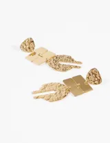 Caravanas colgantes de acero quirúrgico color plateado, compuestas por una pieza superior texturizada, dos rectángulos lisos y una pieza inferior en forma de U con textura martillada.