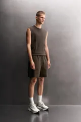 Short jogger marrón de corte relaxed fit, confeccionado en tejido compacto de algodón, con cintura elástica ajustable, bolsillos frontales en la cadera y bolsillo trasero de plastrón.