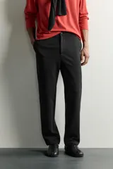 Pantalón negro confeccionado en mezcla de algodón, con cintura elástica, bolsillos frontales y cierre con cremallera y botón.