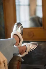 Pantuflas de corderito color blanco, ideales para usar en casa.