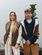 Chaleco color crema con textura de piel sintética, sin mangas y con forro interno.