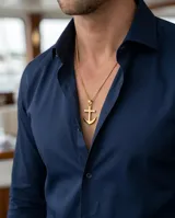 Dije de acero con baño de oro en forma de ancla, con acabado pulido brillante.