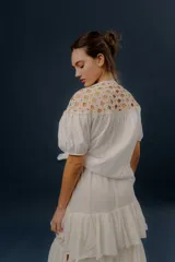 Blusa blanca de algodón con detalles de crochet en la parte superior y mangas cortas abullonadas.