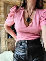 Blusa de lurex rosada con escote en V y mangas cortas abullonadas.