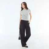 Pantalón ancho de talle alto en color negro, con diseño amplio y fluido, bolsillos laterales y cierre frontal oculto.