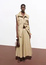 Chaleco oversize color beige, sin mangas, con cuello de solapa, cuatro bolsillos de parche con solapa en la parte delantera, fruncido elástico en la cintura y cierre frontal con botones.