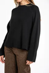 Sweater de algodón color azul, de punto grueso, con cuello redondo y mangas largas.