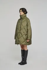 Campera puffer acolchada de corte oversize, color verde oliva, con diseño de rombos, cuello alto y cierre frontal con cremallera.