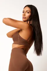 Top deportivo marrón con tecnología seamless, breteles finos y textura con microtramas respirables. Cuenta con forro interno.